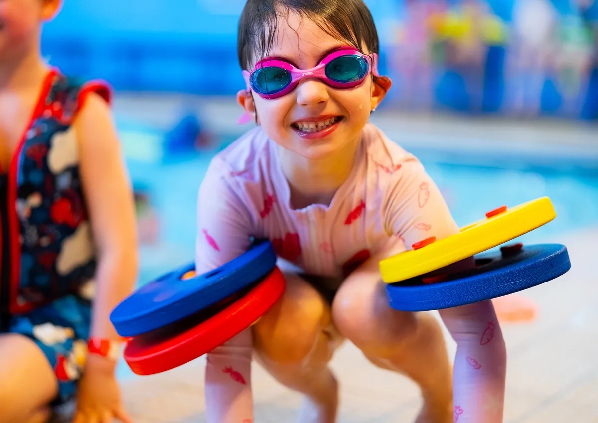 Child wearing swimming goggles during a Billericay Holiday Camp swimming activity at Mayflower High School